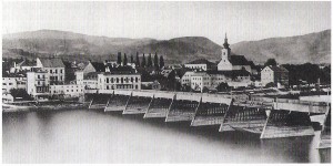 Ein Schiffsunglück des Jahres 1868 bewirkte, dass die seit 1497 bestehende Holzbrücke über die Donau zwischen Linz und Urfahr komplett erneuert wurde. Zwischen 1870 und 1872 wurde der Neubau einer Eisenbrücke auf vier Strompfeilern vorgenommen. Heute steht dort die Nibelungenbrücke. Blick auf die Marktgemeinde Urfahr samt Stadtpfarrkirche. Foto: Sammlung oepb