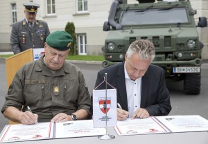Brigadier Nikolaus Egger (links) und Bürgermeister Stefan Karlinger unterzeichnen die Partnerschaftsurkunden. Foto: Bundesheer / Simader