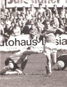 6.500 Zuschauer verfolgten am 16. April 1988 ein rassiges Match am Vorwärts-Platz. Die Heimischen trennten sich vom SK VÖEST 1 : 1 (0 : 0). Rechts im Bild der VÖEST-Spieler Paul Perstling am Weg zum 0 : 1. Steyr-Keeper Erwin Fuchsbichler (links), selbst jahrelanger VÖEST-Torhüter, hatte die Fronten gewechselt und war in dieser Szene bereits geschlagen. Foto: oepb