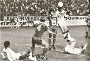 Der beinahe 20-jährige Gerhard Steinkogler (Bildmitte) im Dress des GAK als erfolgreicher Torschütze. Hier eine Spielszene vom 14. September 1979, Linzer Stadion, 11.000 Zuschauer. Aus Linzer ASK gegen den Grazer AK, 1 : 2 (1 : 1). Steinkogler erzielte den Ausgleich. Im Bild von links: Helmut Köglberger https://www.oepb.at/allerlei/helmut-koeglberger-erinnerungen-an-eine-braune-perle.html (LASK, am Boden), Werner Maier (Nr. 4, GAK), Gerhard Steinkogler (GAK), Heinz Singerl (LASK), am Boden Savo Ekmecic (GAK), sowie im Hintergrund Werner Gregortisch (GAK). Quelle und Foto: oepb