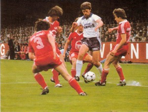 Aus der Bundesliga-Geschichte: Attraktiver und spannender für alle Beteiligten hätte er wohl nicht verlaufen können - der 36. und letzte Spieltag der 1. Division am Samstag, 20. Juni 1981, der einem wahren Foto-Finish glich. Der SK Sturm Graz war 1980 „Herbstmeister“ gewesen und rechnete sich am letzten Spieltag 1980/81 berechtigte Chancen aus, erstmals in seiner bis dato 72-jährigen Vereinsgeschichte Österreichischer Fußballmeister zu werden. Der Rivale in Graz, der GAK, war im Mai des gleichen Jahres bereits Österreichischer Cupsieger geworden. Die Steiermark wäre demnach DAS Fußball-Bundesland in Österreich gewesen. „Wäre“, denn an der Mur flatterten die Nerven. Am letzten Spieltag empfing Sturm in Liebenau den SK RAPID Wien. Diese legten eine beachtliche Frühjahrssaison hin. Im Herbst noch auf Platz Sieben gelegen, sorgte die Rückhol-Aktion von Hans Krankl aus Barcelona im Jänner 1981 für einen wahren Zuschauer-Boom in Hütteldorf. Krankl erfüllte sämtliche in ihn gesteckten Erwartungen und traf in des Gegners Tor, wie zu seinen besten Tagen. 16 Krankl-Tore in 18 Frühjahrsspielen hievten RAPID nach oben und den Goleador ex aequo mit Alfred Drabits (Wiener Sport Club) und Christian Keglevits (RAPID) hinter Gernot Jurtin (Sturm Graz) an die zweite Stelle der Torjägerliste. Am letzten Spieltag duellierte man sich mit Admira/Wacker um den letzten freien UEFA-Cupplatz. Der FK Austria Wien hingegen, zuvor dreimaliger Bundesliga-Meister in Serie, hatte es nicht mehr in der Hand, aus eigener Kraft erneut Fußballmeister zu werden. Dennoch war man im Lager der Violetten zuversichtlich, empfing man doch „zu Hause“ am Sportclub-Platz den GAK, der mit dem Cupsieg sein Plansoll für die Saison 1980/81 bereits übertroffen hatte. 8.000 Zuschauer am Sportclub-Platz vertrauten auf ihre Violetten. Volksfeststimmung hingegen in Graz. Über 20.000 Zuschauer wollten den SK Sturm zum ersten Meistertitel in der Geschichte peitschen. Doch die Sturm-Truppe war dazu einfach nicht in der Lage. RAPID führte zur Pause mit 1 : 0. Am Sportclub-Platz hingegen tanzte man bereits den violetten Walzer. 5 : 1-Pausenführung für den FAK gegen den GAK. Selbst bei einem etwaigen Unentschieden in Graz wäre man Meister gewesen. Sturm mühte sich in der zweiten Hälfte und rannte an, nach 49 Minuten stand es 1 : 2. Dennoch hätten die Grazer gewinnen müssen, um noch den lange gehegten Titel-Traum auch leben zu können, denn aus Wien hieß es plötzlich 6 : 1 für die Austria. Andererseits war RAPID nicht umsonst die beste Frühjahrsmannschaft 1981. Man blieb aus Hütteldorfer Sicht in Graz mit 4 : 1 erfolgreich und belegte in der Schlussabrechnung noch den dritten Platz. Sturm war „nur“ Vizemeister geworden, denn die Austria spielte ihr Match souverän nach Hause und holte damit den vierten Meistertitel in Serie. Ein Rekord, der 37 Jahre Bestand hatte und erst vom FC Red Bull Salzburg im Jahre 2018 überboten wurde. Die Bundeshauptstadt Wien konnte jubeln, denn mit der Austria stellte man den „alten“ und den „neuen“ Meister und RAPID kam als Drittplatzierter noch in den UEFA-Cup. Austria-Kapitän Robert Sara meinte spontan nach dem Spiel, RAPID für die Schützenhilfe dankbar zu sein. Er wolle nun gleich in die Kirche gehen und für die Rapidler eine Kerze anzünden. Im Bild (Bildmitte) Austrias Primgeiger Felix Gasselich, der gekonnt durch die Reihen der Grazer Rotjacken tänzelt auf dem Werg zum 3 : 0 in der 14. Spielminute. Nr. 3: Mario Mohapp, Harald Gamauf und Klaus Sprik, sowie rechts Hans Sommer (alle GAK). Aus FK Austria Wien gg. GAK, 6 : 1 (Pausenstand 5 : 1) vom 20. Juni 1981.Quelle und Foto: © oepb