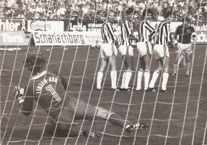 Aus der Bundesliga-Geschichte: Die Saison 1981/82 war nach vier gespielten Runden noch sehr jung, als am 5. Spieltag, einem Samstag, 12. September 1981 um 16 Uhr im Linzer Stadion der LASK und der SK VÖEST Linz zum ersten von insgesamt vier Stadt-Derbys der Saison antraten. Der SK VÖEST galt als Favorit und hätte bei einem vollen Erfolg zur Tabellenspitze aufschließen können. Der LASK startete durchwachsen in die neue Spielzeit und lag in der 10er Liga an der 8. Stelle. Die Gugl war mit 13.500 Zuschauern gut besucht und an jenem Tag auch das Stadion mit den meisten Zuschauern in Österreich. Und es kam, wie es so oft gerade in Derbys immer wieder passiert – der Favorit strauchelte. VÖEST´s Paradestürmer Max Hagmayr war bei Kurt Nagl https://www.oepb.at/allerlei/kurt-wolfgang-nagl-admiraner-im-lask-dress.html in guten Händen und Willi Kreuz, https://www.oepb.at/allerlei/wilhelm-willy-kreuz.html Dreh- und Angelpunkt des SK VÖEST-Spiels scheiterte – wie hier auf dem Schnappschuss aus der 1. Spielhälfte, mehrmals an LASK-Keeper Klaus Lindenberger. Im Bild von links: Klaus Lindenberger, Jupp Bläser, Wolfgang Nagl, Josef Lenhart, Karl Meister (alle LASK), sowie Willi Kreuz (SK VÖEST). Aus LASK gg. SK VÖEST Linz vom 12. September 1981 vor 13.500 Zuschauern im Linzer Stadion, 1 : 0 (Pausenstand 0 : 0). Quelle und Foto: © oepb 